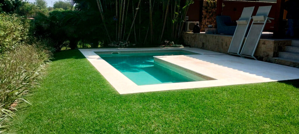 Uma piscina com o formato de L em um quintal de uma casa - reforma-de-piscina-em-residencia-rio-de-janeiro