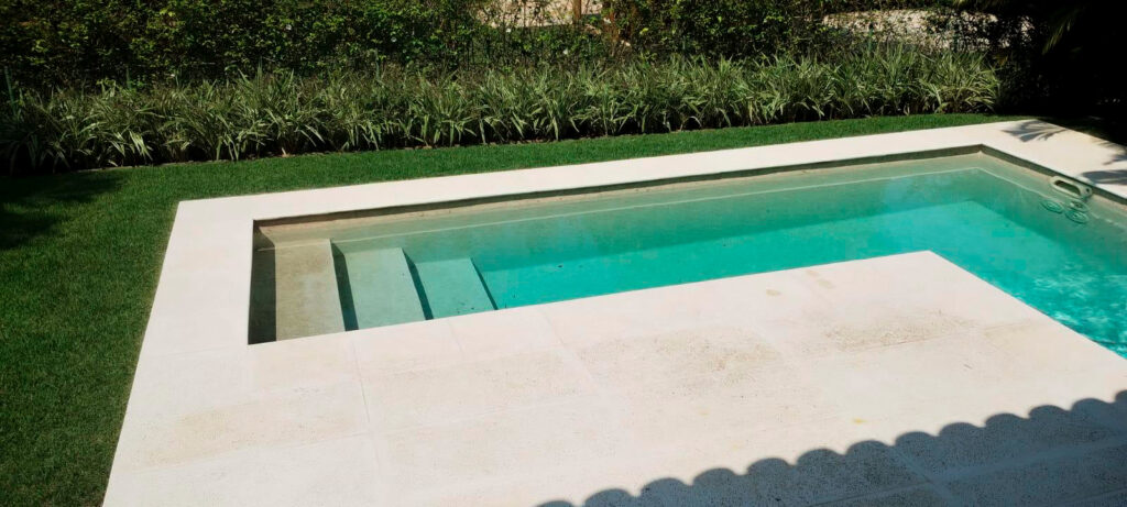 Uma piscina com o formato de L em um quintal de uma casa - reforma-de-piscina-em-residencia-rio-de-janeiro