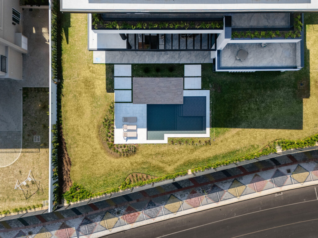Vista aérea de uma piscina Desjoyaux localizada em um quintal de uma residência - projeto-de-piscina-em-guarapuava