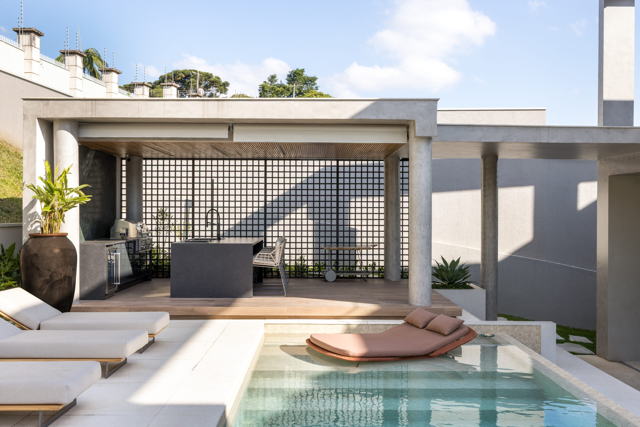 Uma área externa com uma piscina Desjoyaux com borda infinita