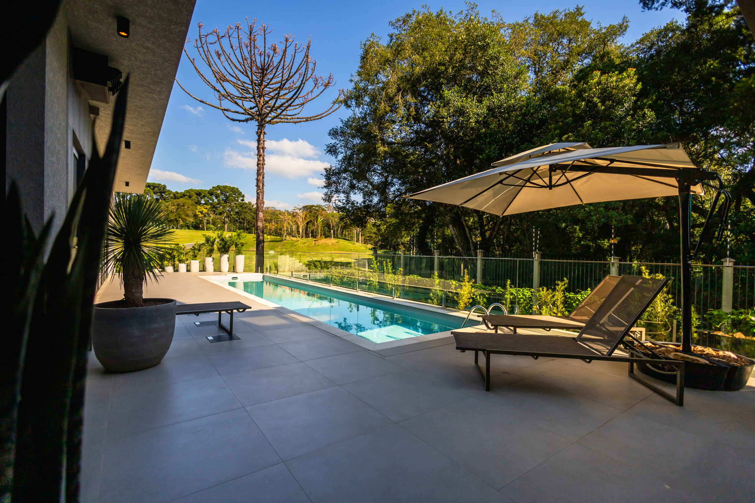Piscina Desjoyaux em um ambiente externo cercado por uma paisagem da área externa da casa
