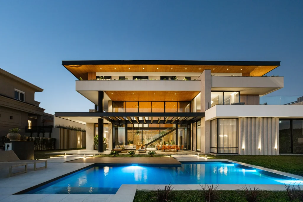 Ambiente externo de uma Mansão com piscina grande e cor escura